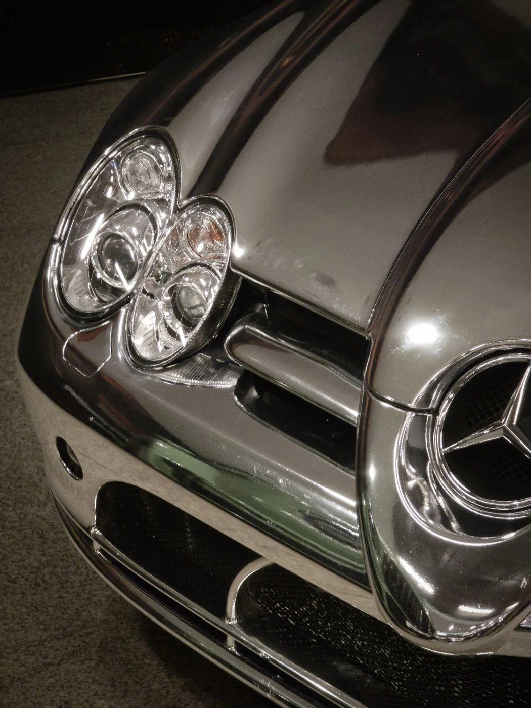 Detal reflektorów i maski srebrnego Mercedesa