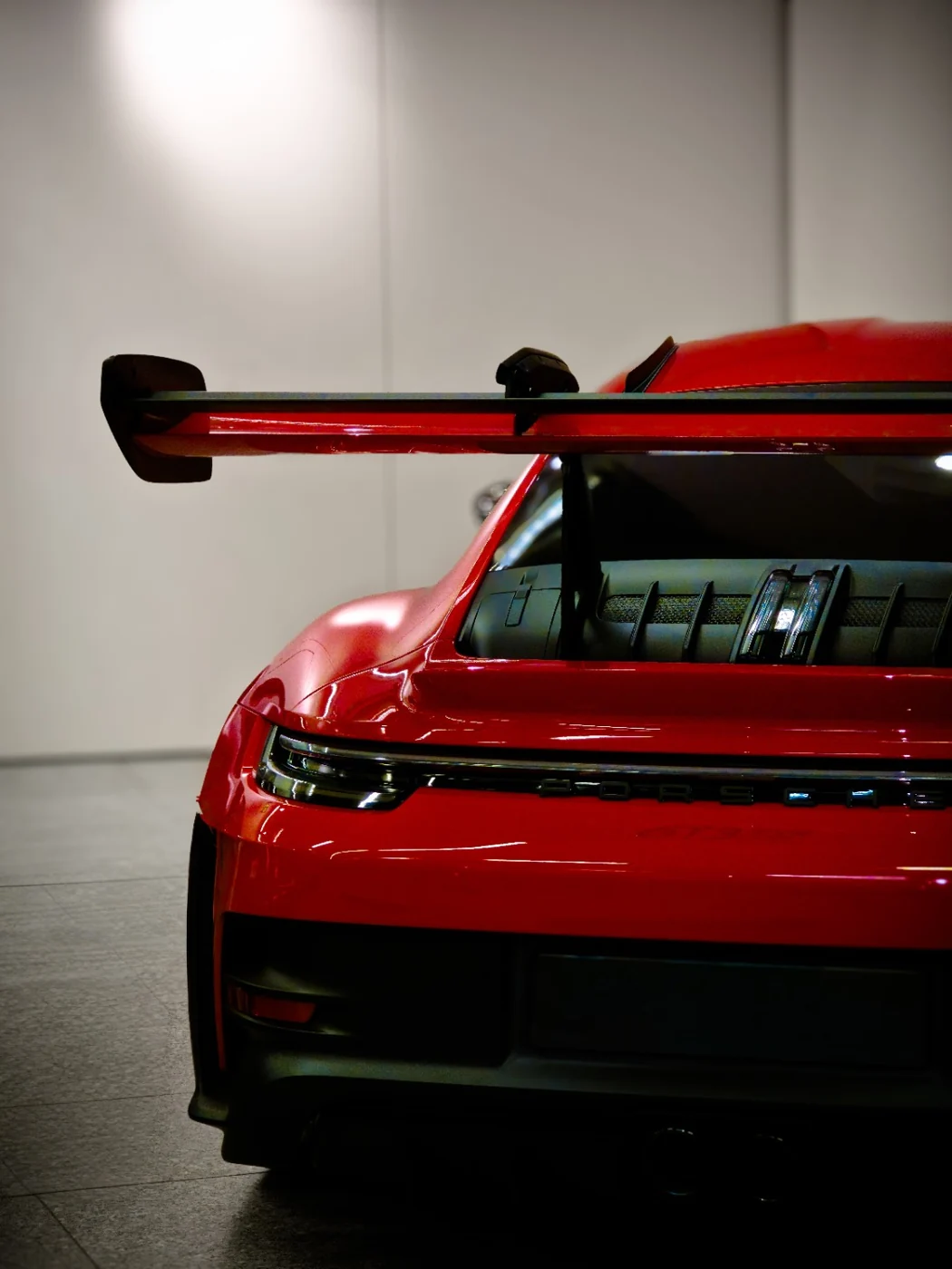 Tył czerwonego Porsche z dużym spojlerem na wystawie